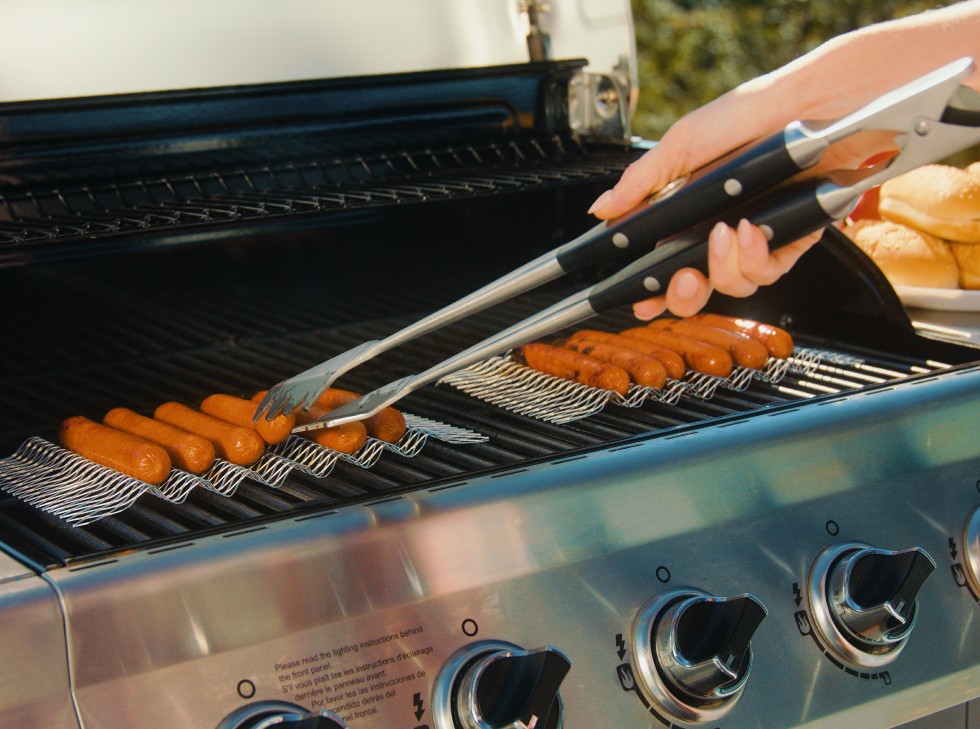 Family Disposable Grill Topper Set 4 Oscarware® Disposable-Hot-Dog-Grill-Topper on the grill.